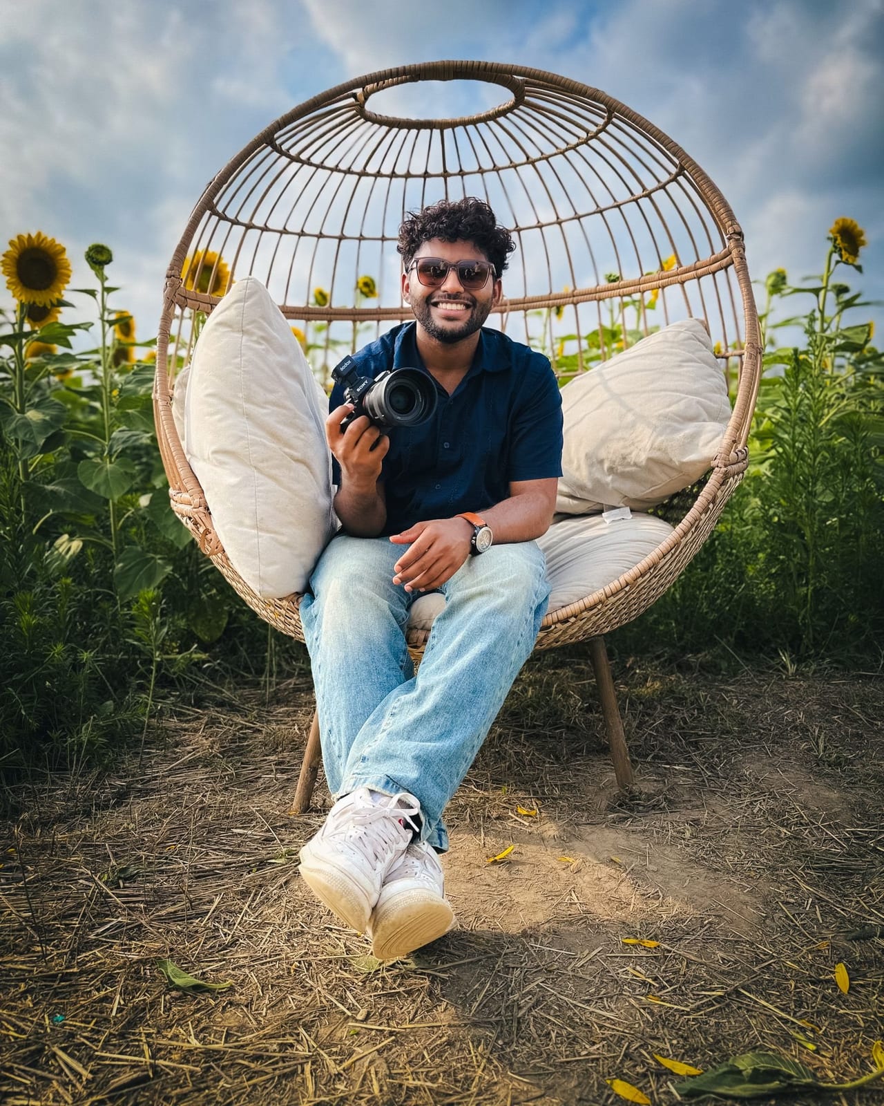 Albin, the photographer behind Aura Films, holding his camera in a sunflower field