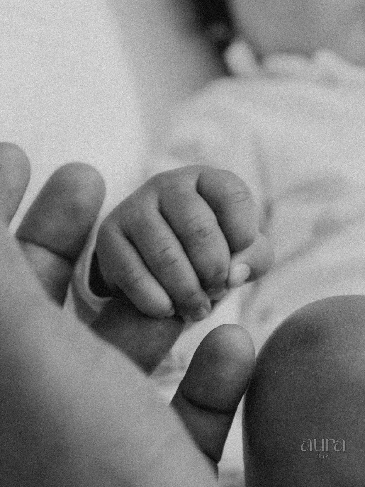 A newborn’s tiny hand wrapped around a parent’s fingers