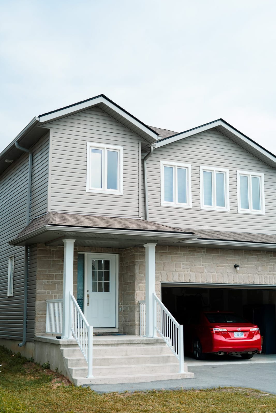 A two-storey home with a stone facade and white trim