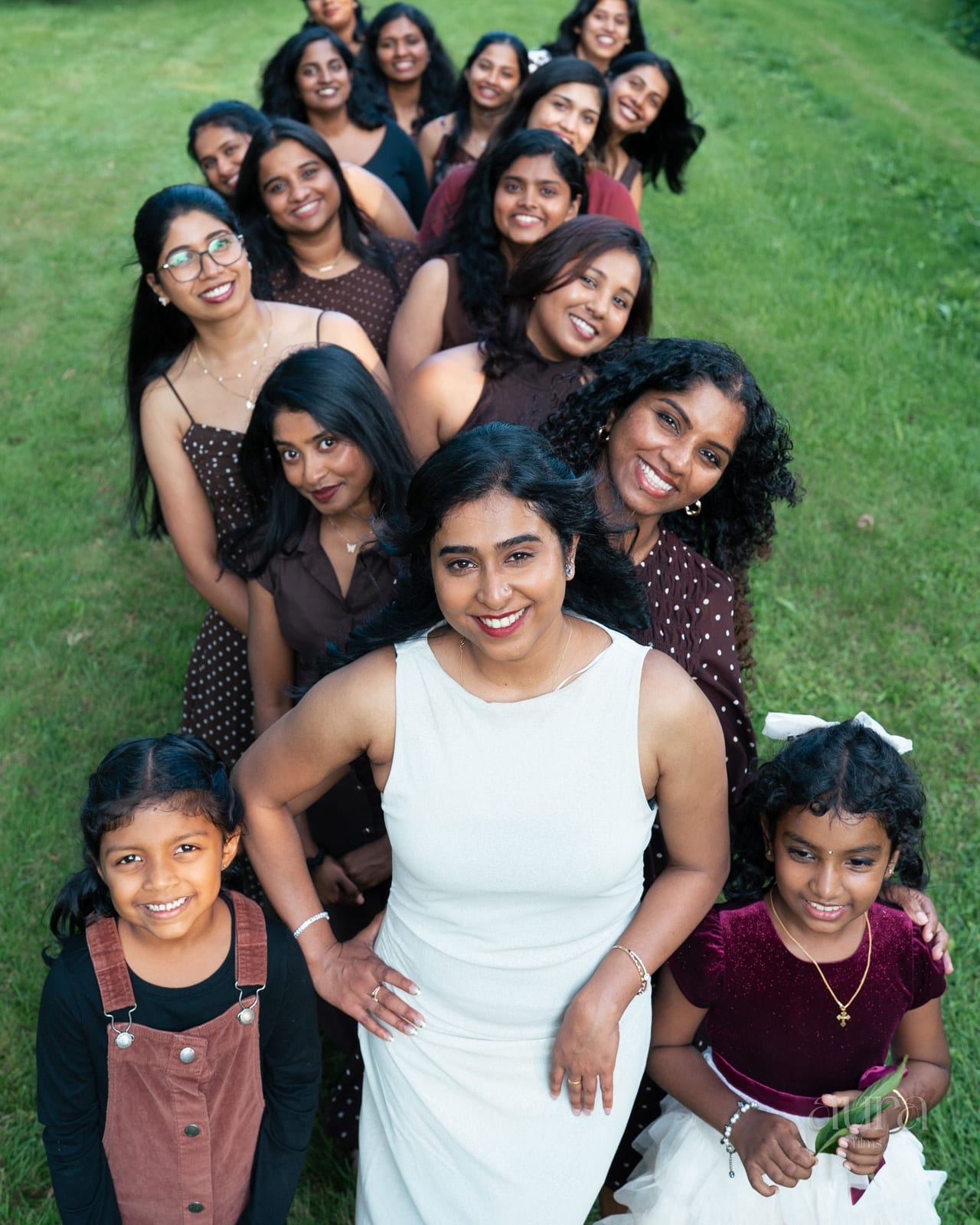A bride in white surrounded by her bridesmaids and flower girls